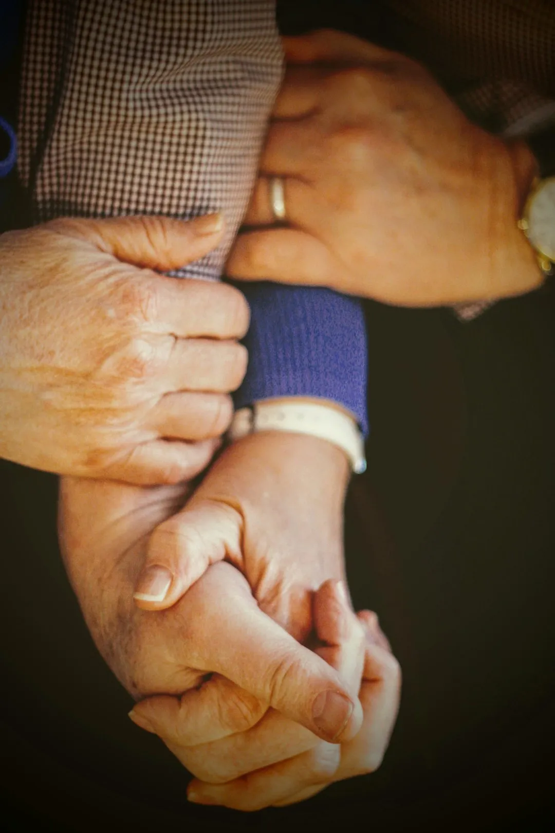 Three pairs of hands held together in a supportive gesture