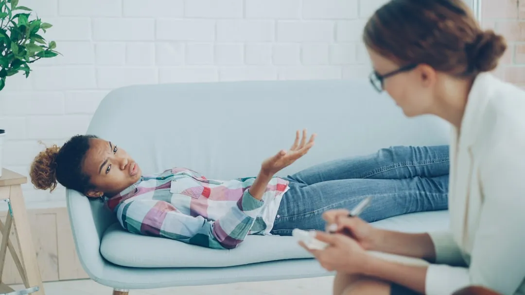 A therapist listening attentively while a client talks during a counseling session